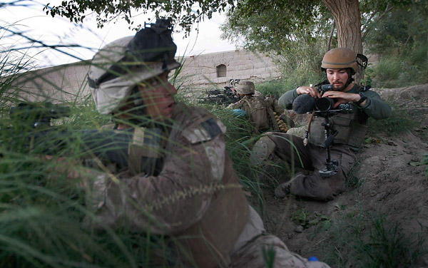 Embedded photojournalist Danfung Dennis in action with his Canon 5DmkII while following the 2nd Marine Expeditionary Brigade, RCT 2nd Battalion 8th Marines Echo Co. (Photo by Joe Raedle/Getty Images)